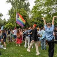 A group of people dancing and celebrating in the pride park