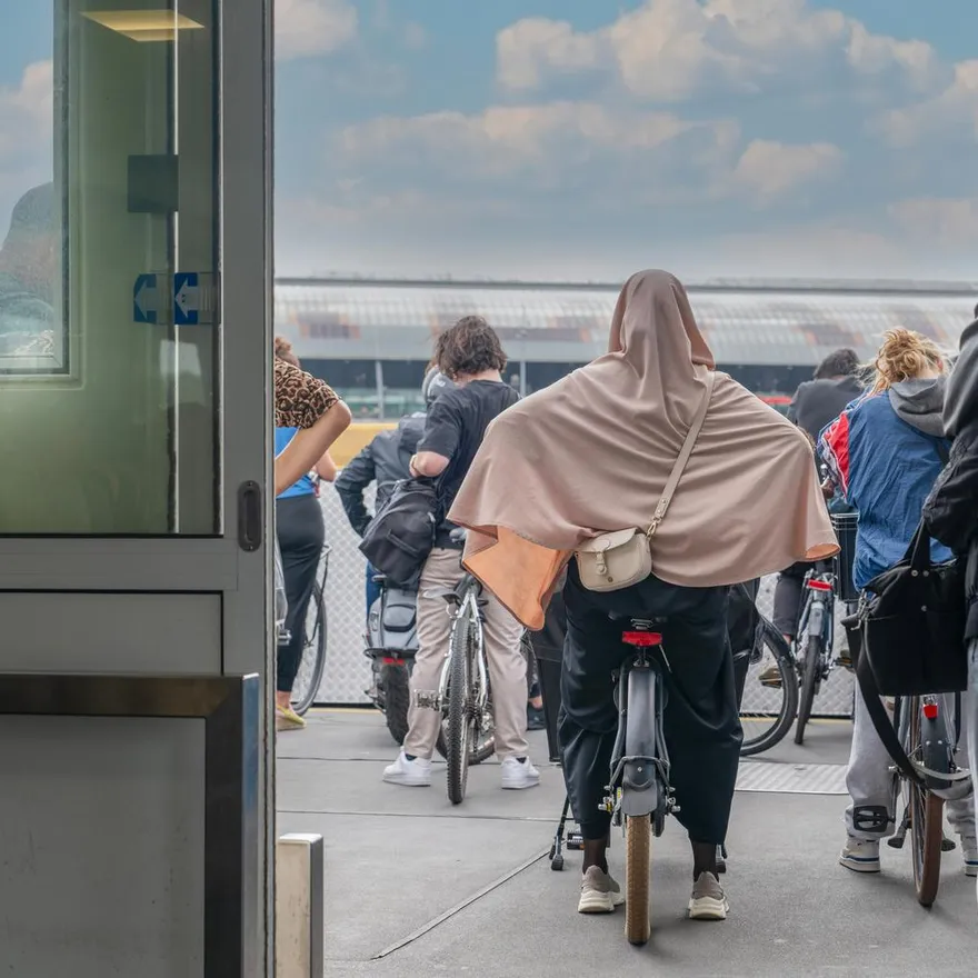 Back rear view of cyclists waiting on the boat heading towards the central station