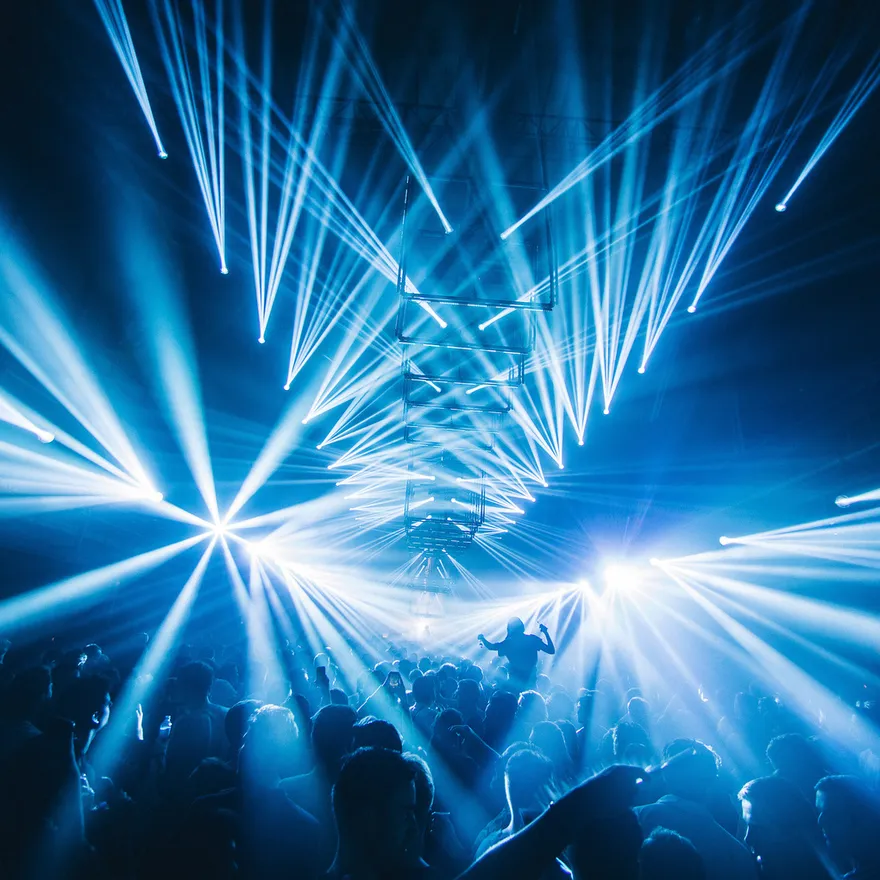 People on the dancefloor under the blue disco lights.