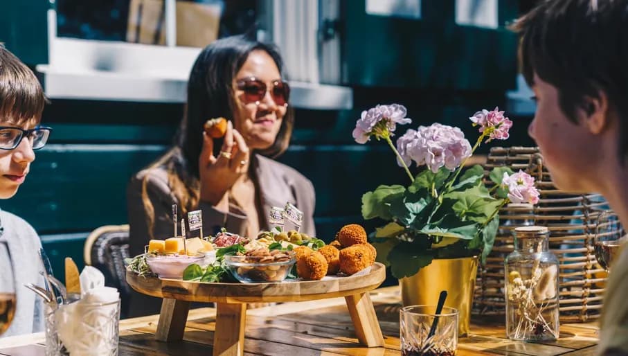People enjoying drinks and bitterballen at Theehuis Cruquius.