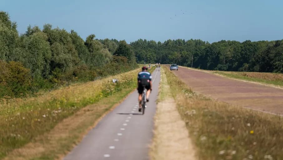 A cyclist on De Knardijk. An inner dike that forms the border between eastern and southern Flevoland as a land divide.