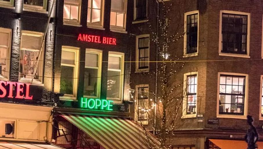 People having drinking outside Cafe Hoppe brown bar