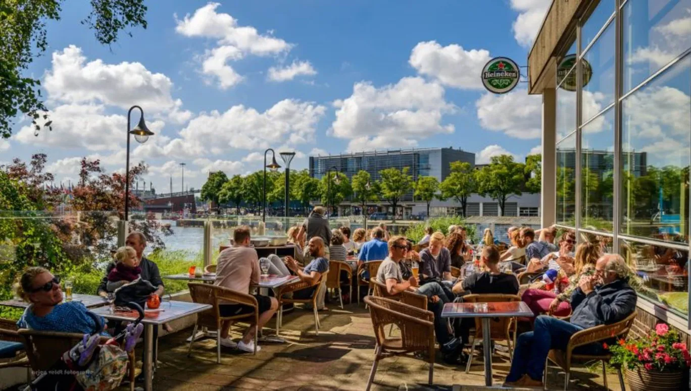 People sitting on the terrace of Pension Homeland at the Marineterrein