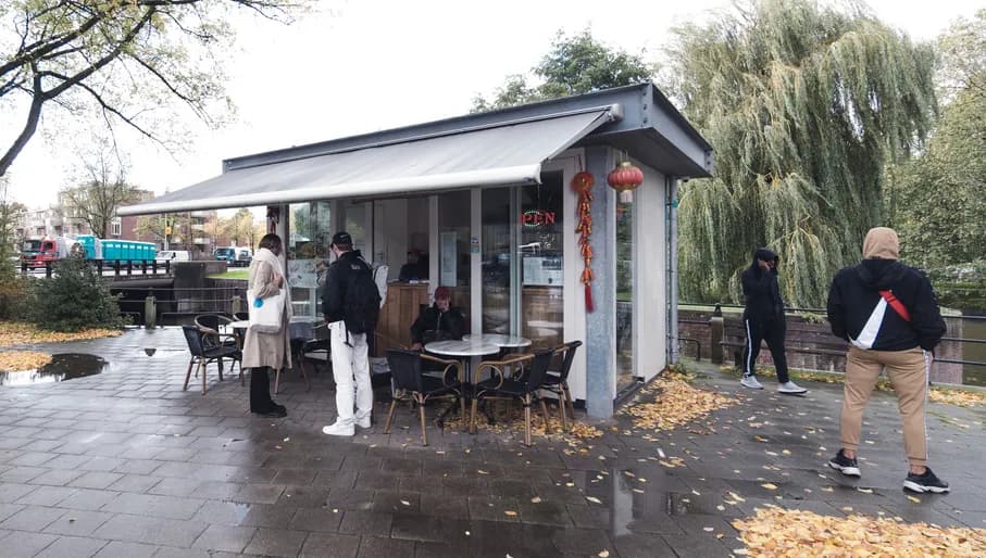 People standing outside the Dumplings snack bar waiting for some delicious duck pancakes