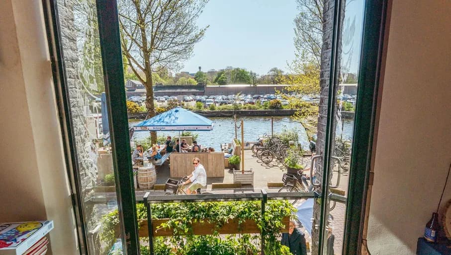 Poeple sitting on a terrace next to the water