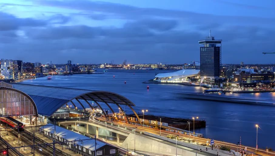 Skyline view of Amsterdam's waterfront facing the Ij River, with A'dam Toren and Amsterdam Eye.