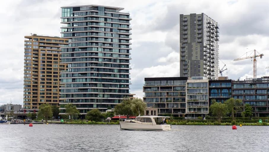 View over De Amstel river, boat passing by high buidings